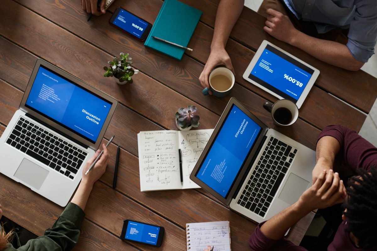 A team collaborating around a table with data dashboards